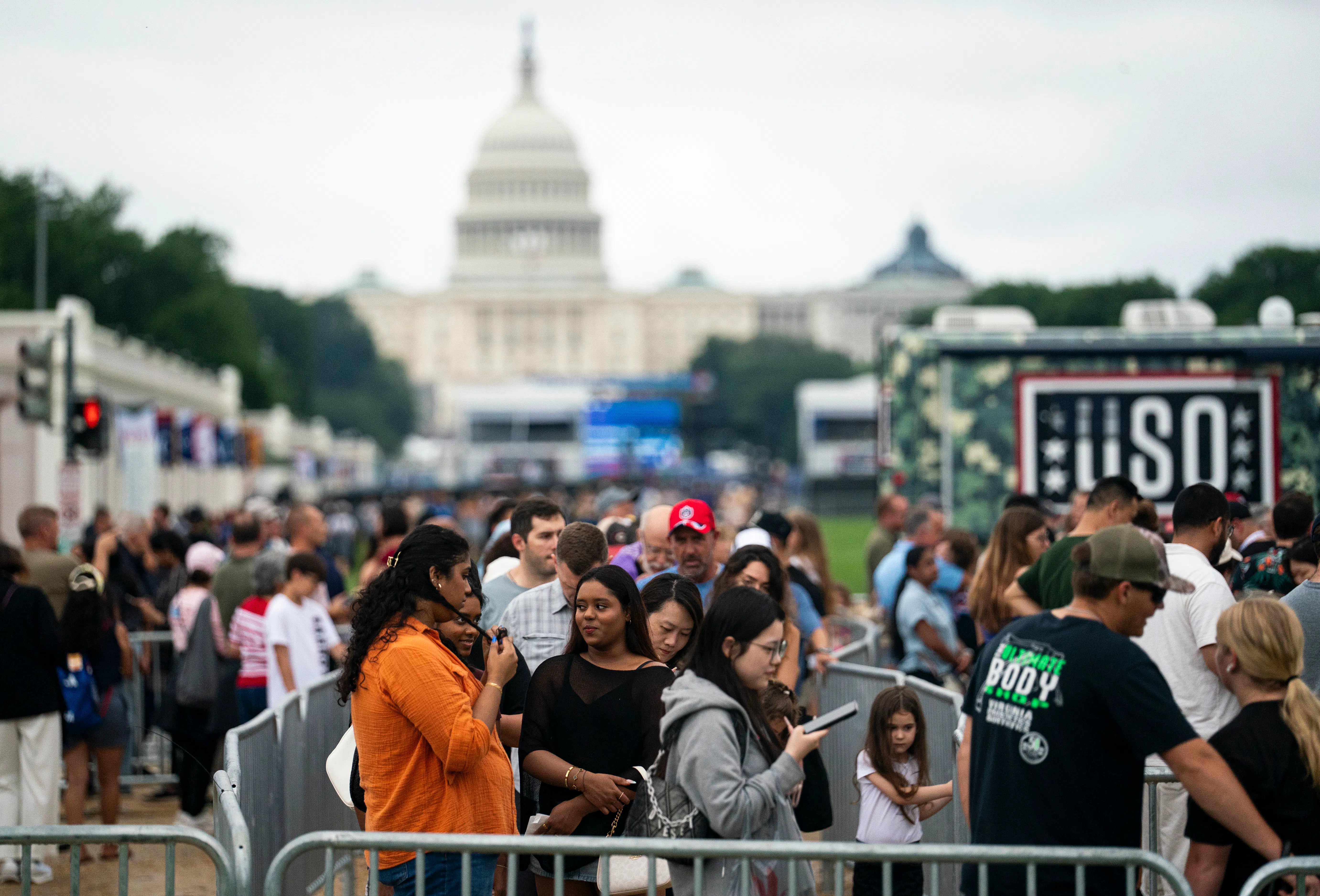 A crowd of people pack the National Mall in front of the Capitol building.