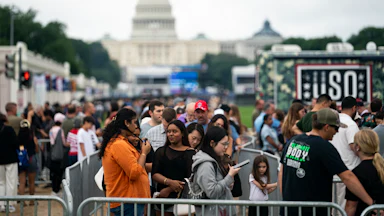 A crowd of people pack the National Mall in front of the Capitol building.