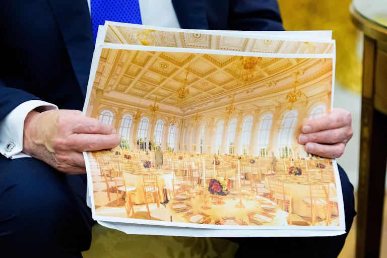 Donald Trump holds up a rendering of the White House ballroom
