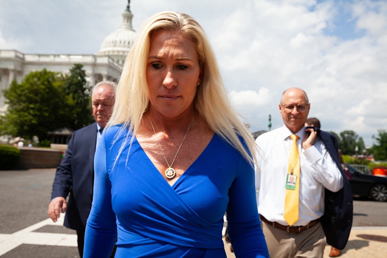 Marjorie Taylor Greene looks downward as she walks outside