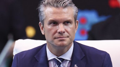 Defense Secretary Pete Hegseth sits during an event