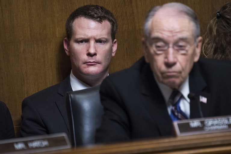 Mike Davis sits behind Chuck Grassley in a congressional briefing