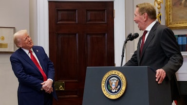 Larry Ellison leans back and smiles as he looks at Trump while speaking at the White House