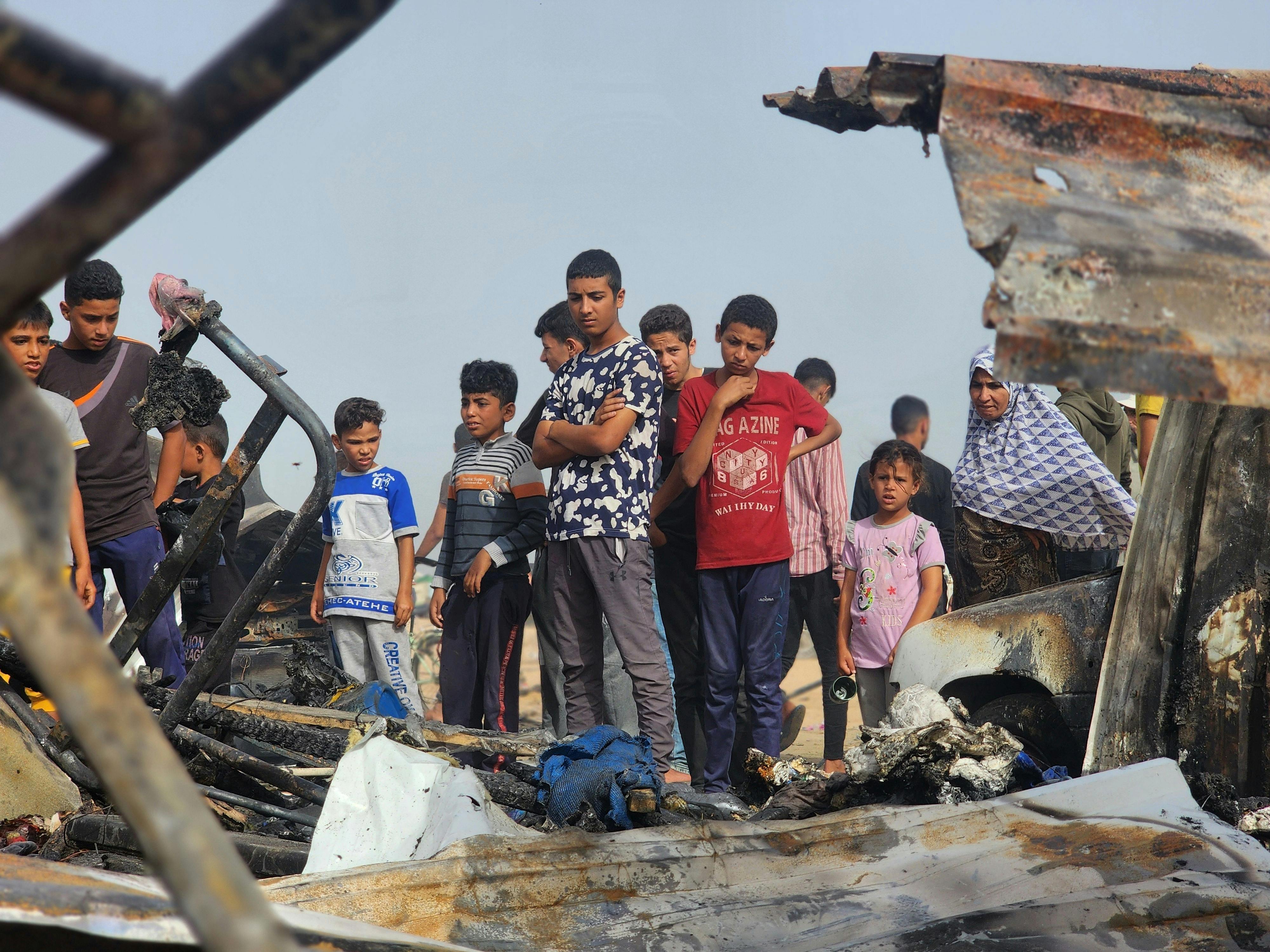Palestinians view the destruction after Israel bombed their tents and shelters in Rafah, Gaza