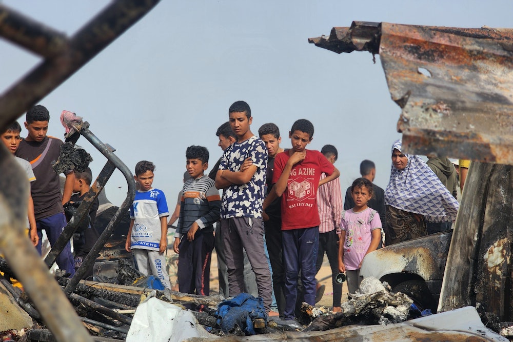 Palestinians view the destruction after Israel bombed their tents and shelters in Rafah, Gaza