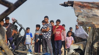 Palestinians view the destruction after Israel bombed their tents and shelters in Rafah, Gaza