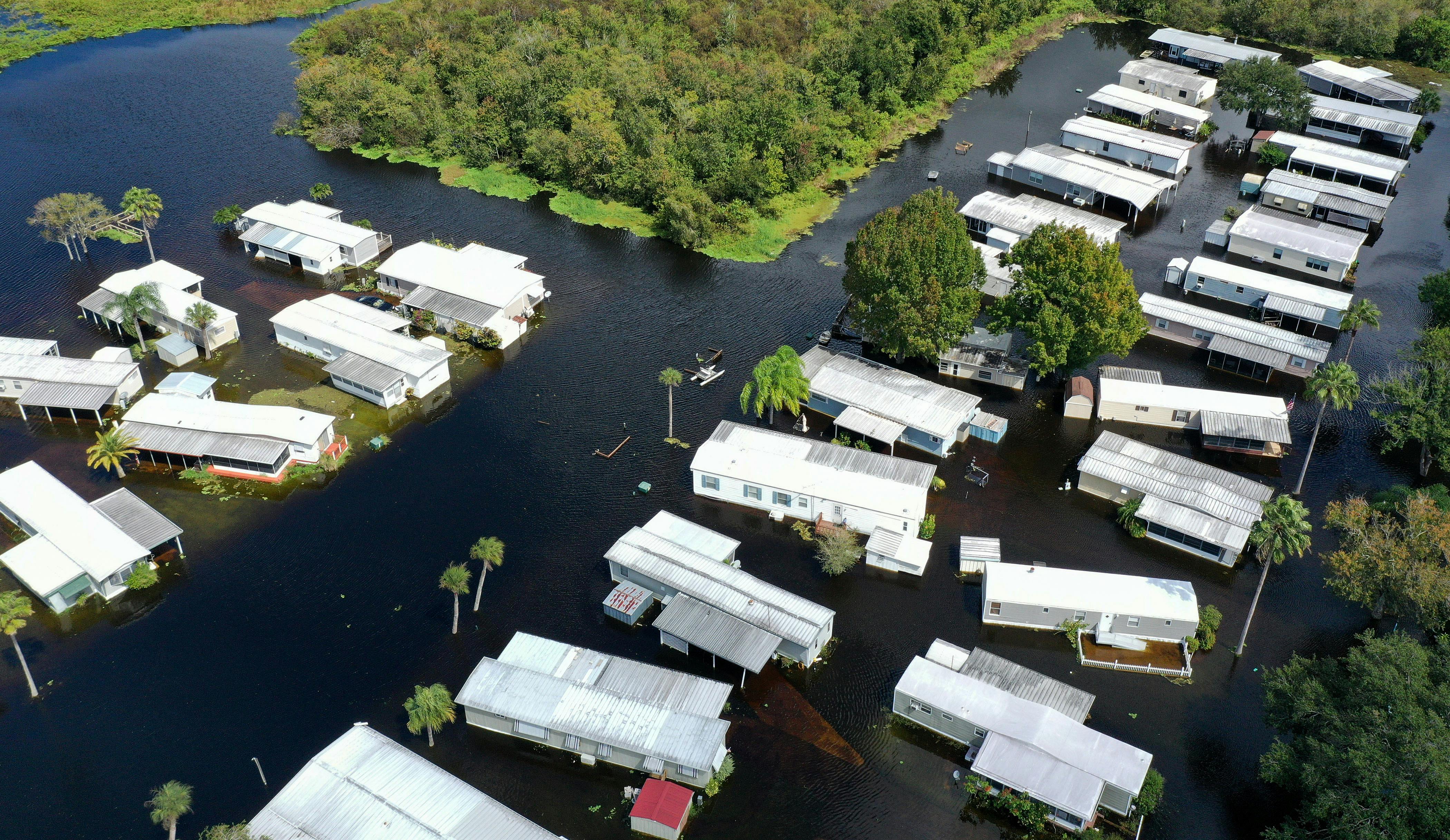 An aerial view shows mobile homes completely surrounded by water.
