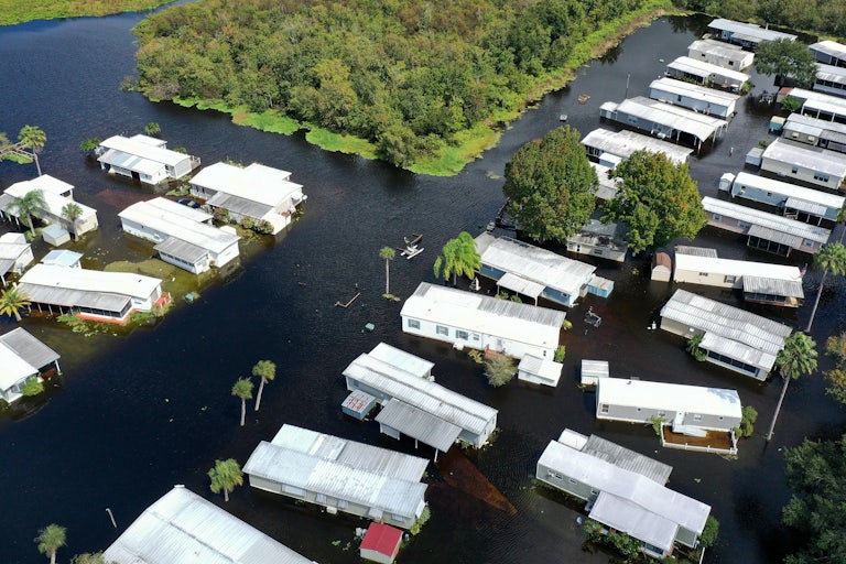 An aerial view shows mobile homes completely surrounded by water.