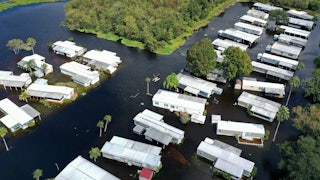An aerial view shows mobile homes completely surrounded by water.