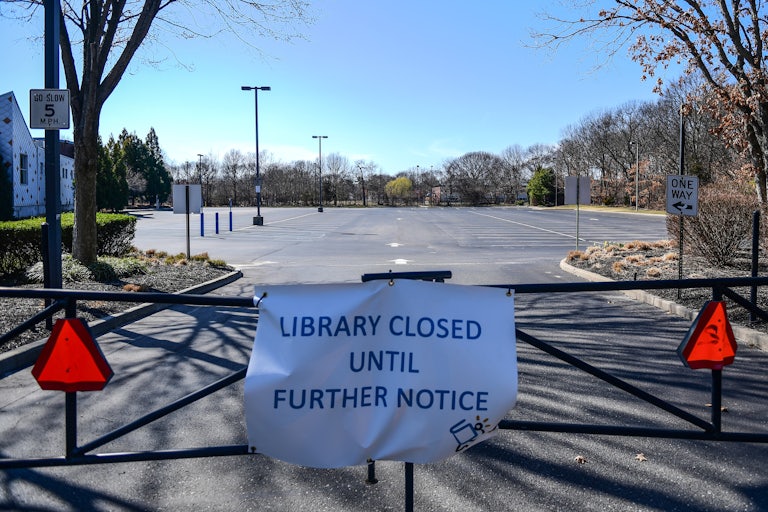 A sign on a gate reads "Library closed until further notice."