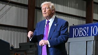 Donald Trump puckers his lips and dances on stage at an event