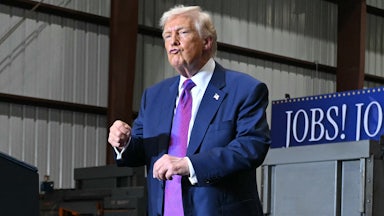 Donald Trump puckers his lips and dances on stage at an event