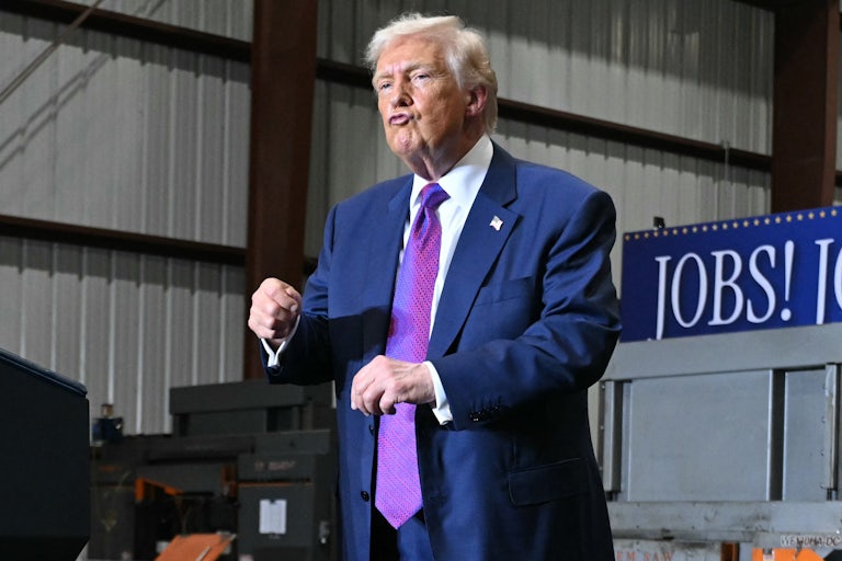 Donald Trump puckers his lips and dances on stage at an event