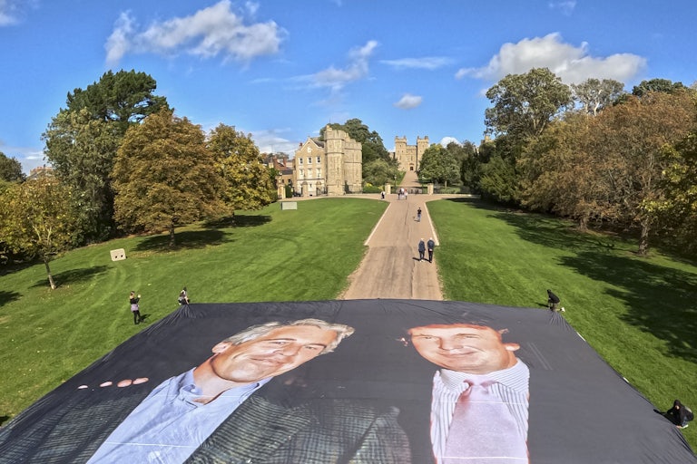 Activists unfurl a large photo of Donald Trump and Jeffrey Epstein outside Windsor Castle.