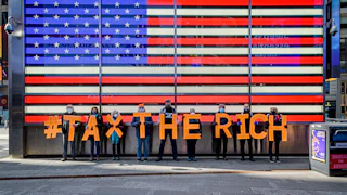 Participants seen spelling out #TaxTheRich at Times Square.