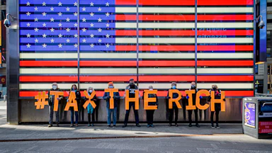 Participants seen spelling out #TaxTheRich at Times Square.