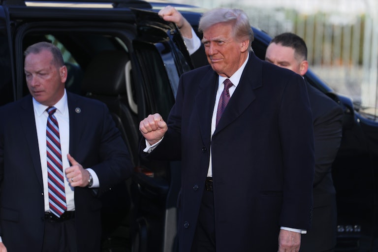 Donald Trump pumps his fist as he arrives at the White House before his inauguration