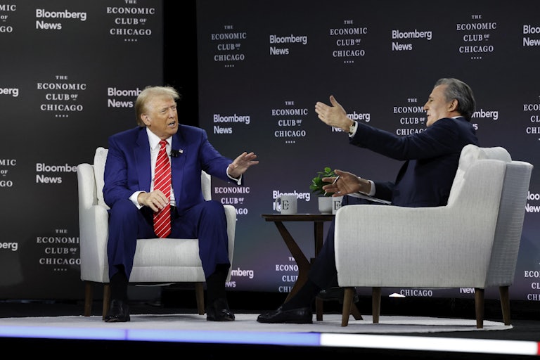 Donald Trump yells on the stage and puts up a hand as if to get Bloomberg’s John Micklethwait to stop talking