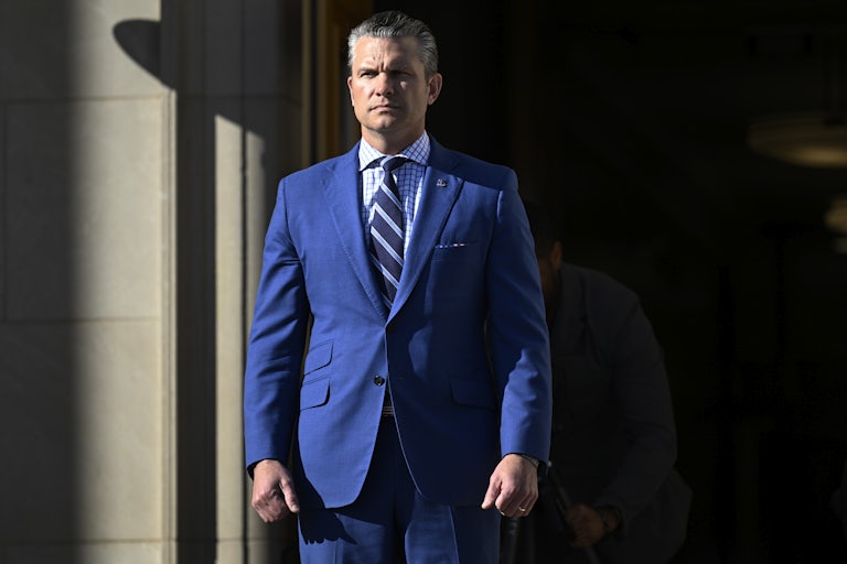 Defense Secretary Pete Hegseth stands at the entrance of the Pentagon
