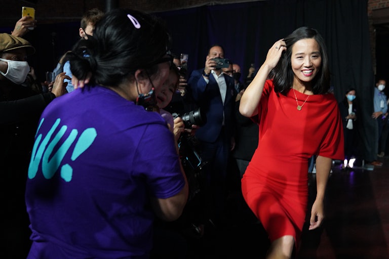Michelle Wu smiles, walking past supporters.