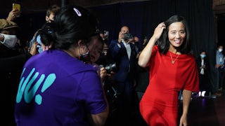 Michelle Wu smiles, walking past supporters.