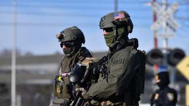 Two masked ICE agents wearing camo (in the snow)