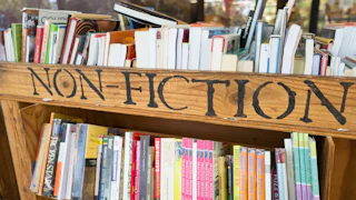 cart of books with a sign reading "non-fiction"