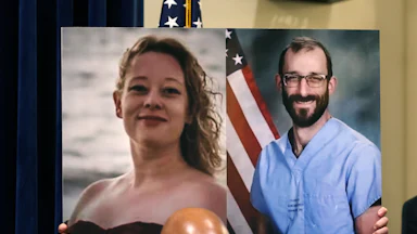 Someone holds up a photo of Renee Nicole Good and Alex Pretti.