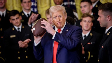 Trump lovingly holds a football
