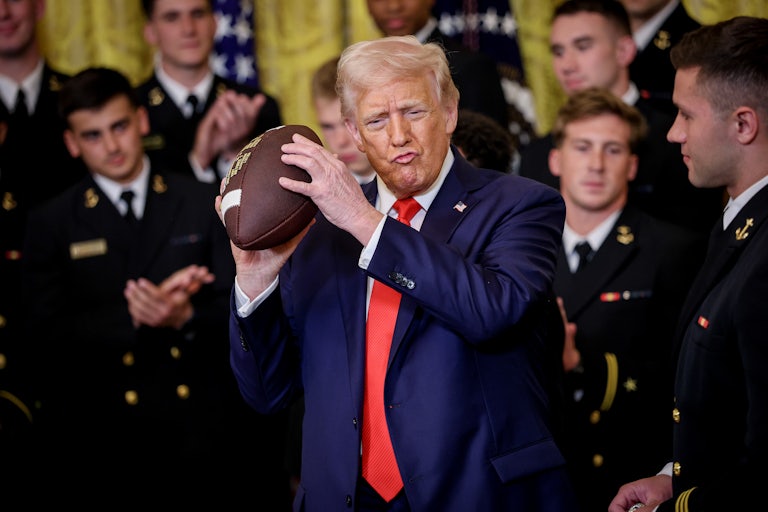 Trump lovingly holds a football