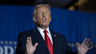 Donald Trump speaks at a reception, using his hands.