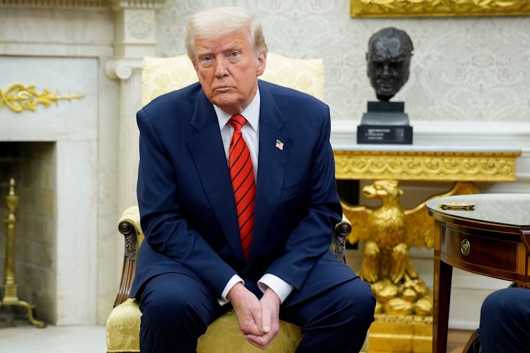 Donald Trump sits with his hands folded in the Oval Office