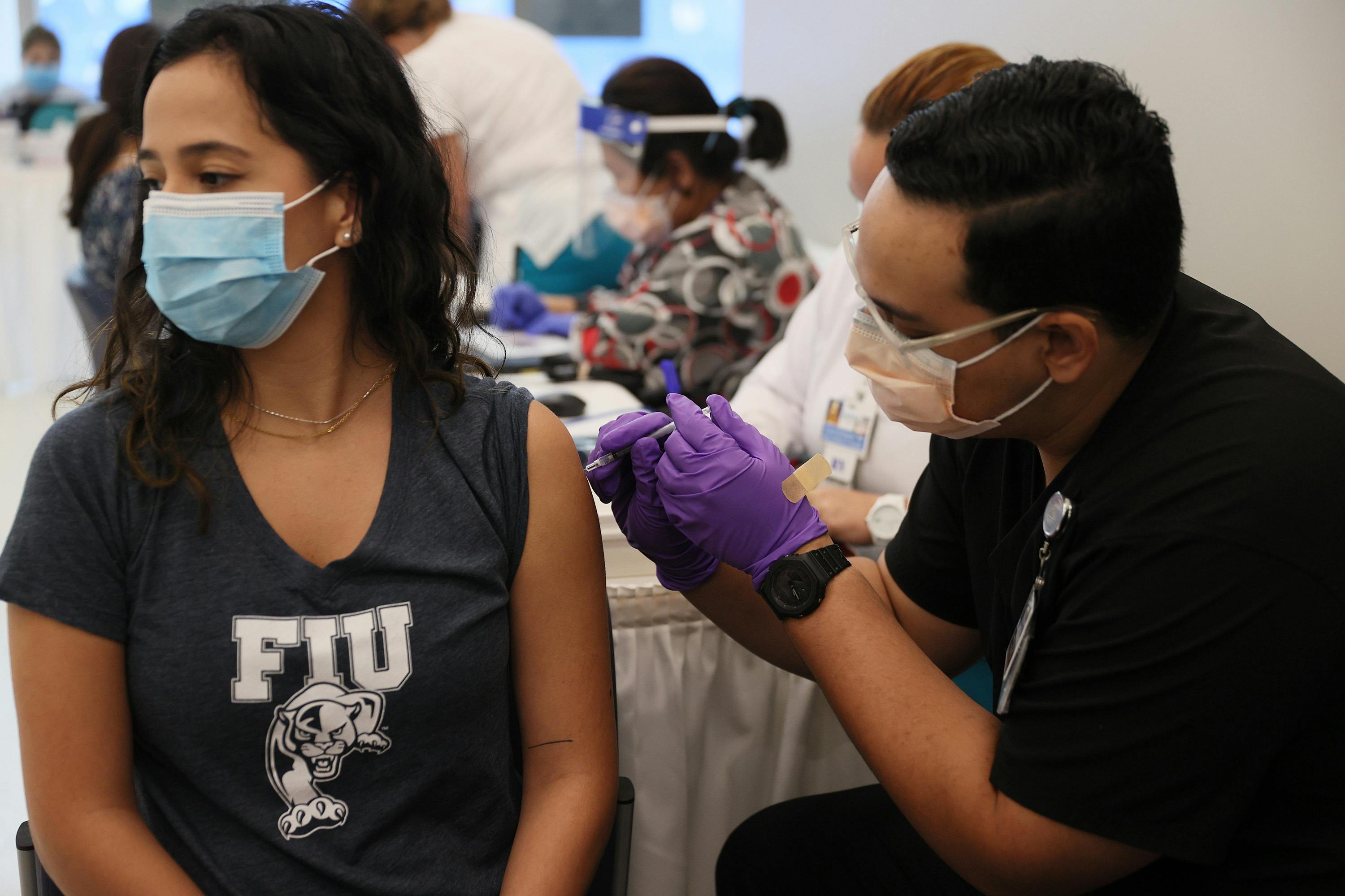 A woman looks away as she receives a Covid-19 vaccine at a hospital in Florida. 