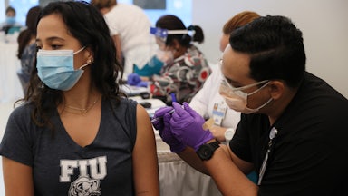 A woman looks away as she receives a Covid-19 vaccine at a hospital in Florida.