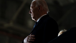 Former President Joe Biden takes his hand to his heart during the National Anthem.