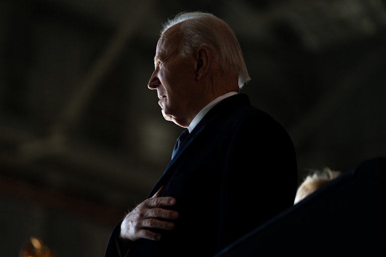 Former President Joe Biden takes his hand to his heart during the National Anthem.