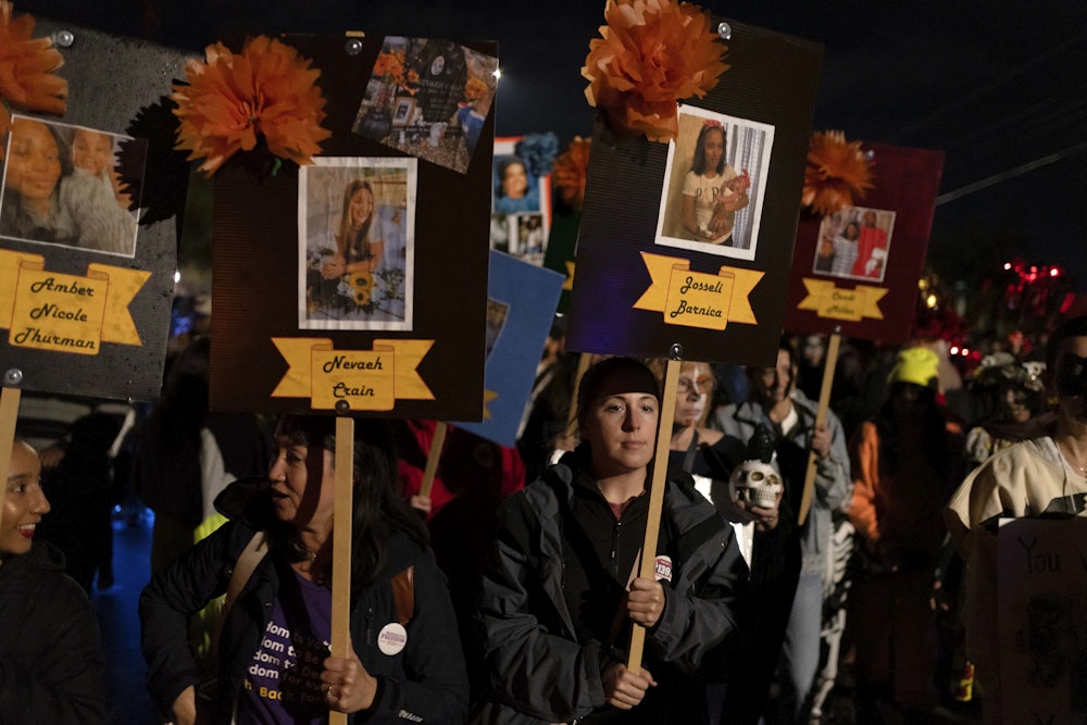 People carry placards with the names and pictures of women who died after being denied abortions.
