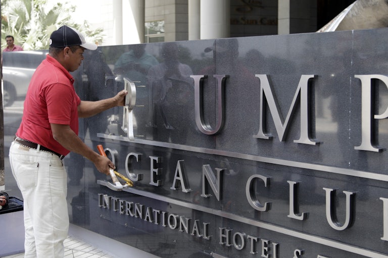 A worker removes the Trump sign letters from outside the hotel in Panama City.