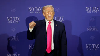 Donald Trump stands with his fist raised and his mouth open