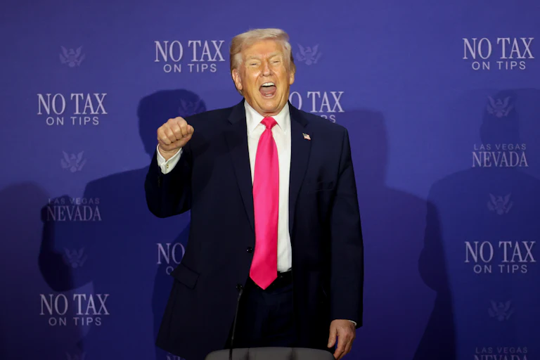 Donald Trump stands with his fist raised and his mouth open