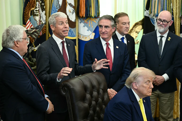 President Donald Trump falls asleep as Secretary of Energy Chris Wright speaks behind him. Others stand around them, including Secretary of the Interior Doug Burgum.