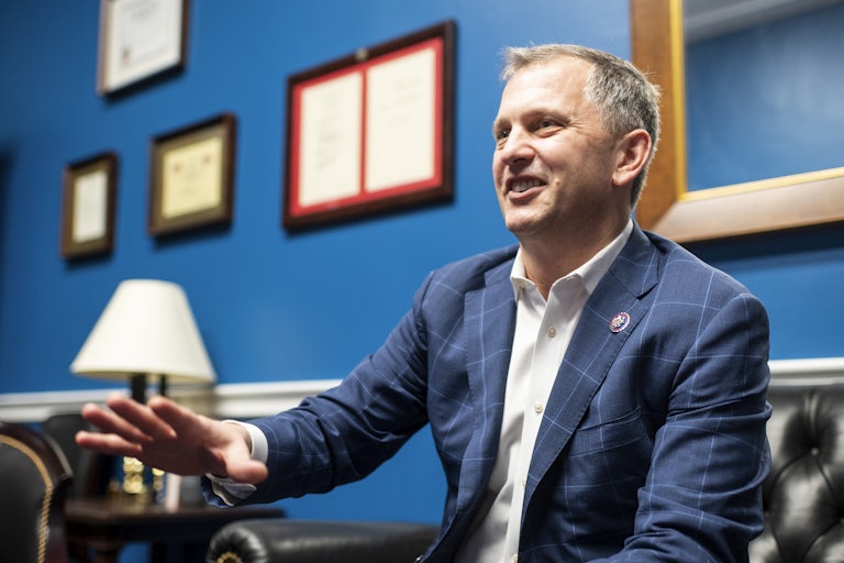 Bill Casten is seated and laughing