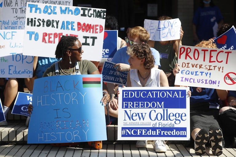 People hold protest signs