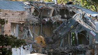Workers demolish the facade of the East Wing of the White House.