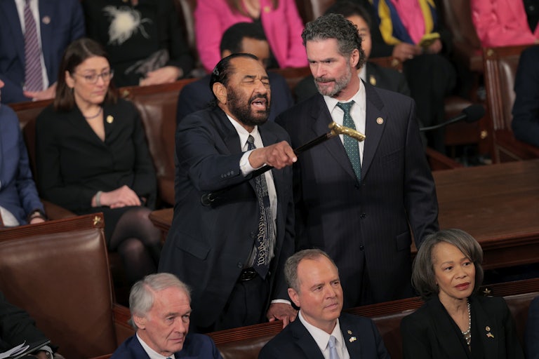 Representative Al Green yells and waves his cane in the Capitol chamber during Trump's speech.