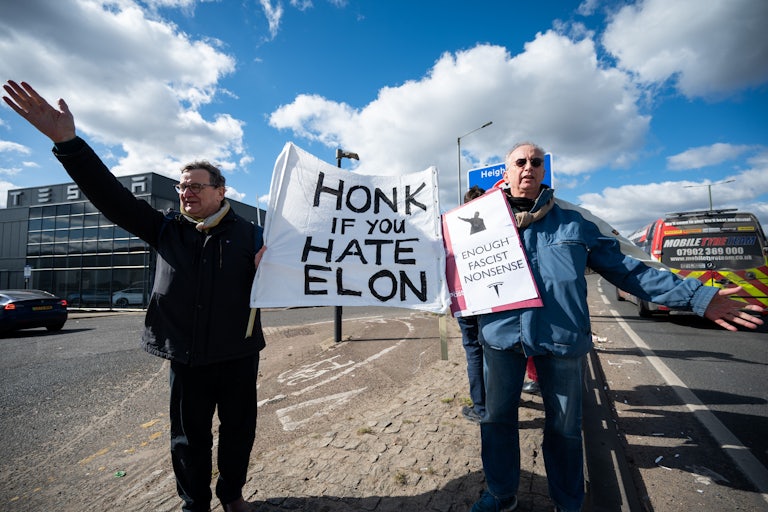 People protest against Elon Musk outside of a Tesla dealership in London, England