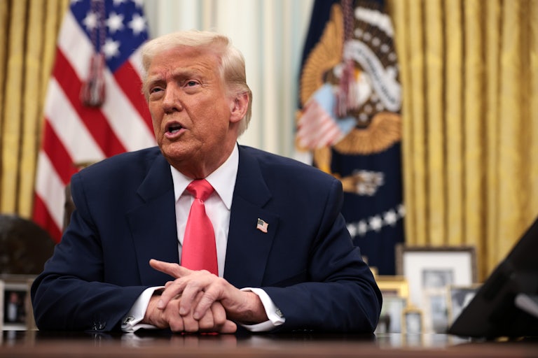 Donald Trump speaks while seated at his desk in the Oval Office.