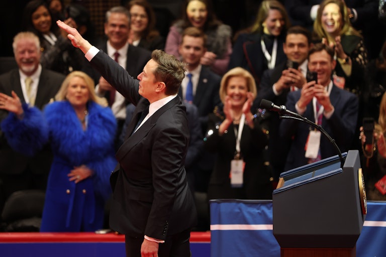 People applaud as Elon Musk does a Roman salute on stage during Donald Trump’s inauguration