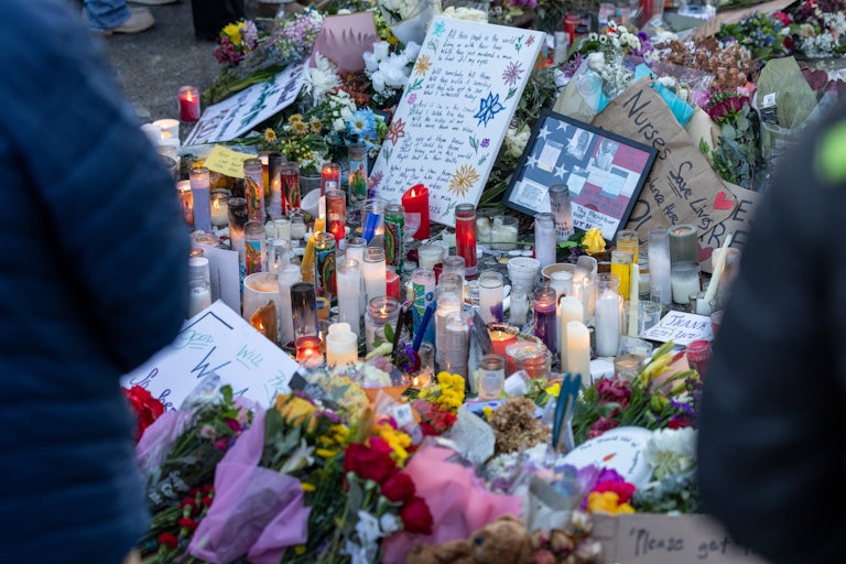 People stand around a memorial for Alex Pretti, who was shot dead by federal immigration agents in Minneapolis.