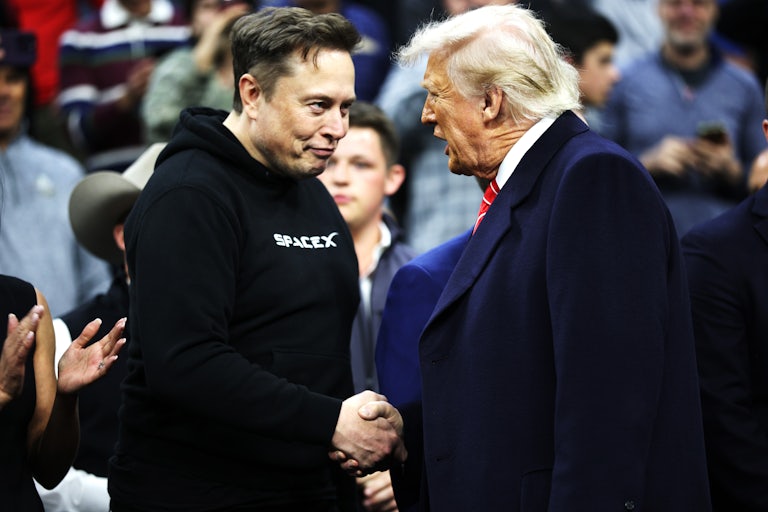 Elon Musk and Donald Trump shake hands while attending a college wrestling championship in Philadelphia
